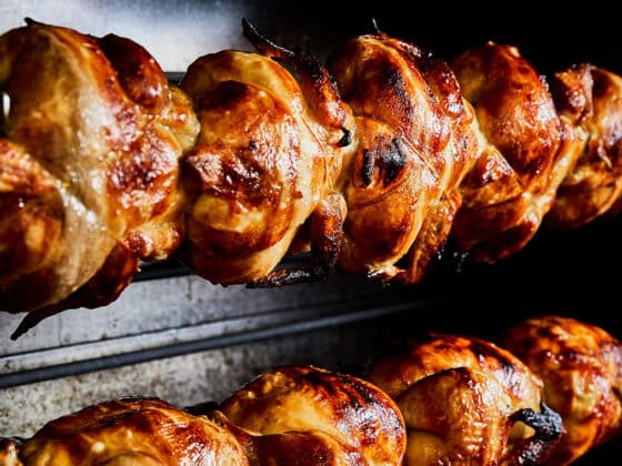 Chickens roasting on rotisserie spit.